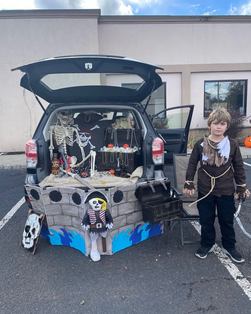 A trunk decorated as a pirate ship with skeletons and treasure